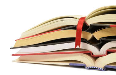 Small pile of open books with red bookmark ribbon isolated on white background
