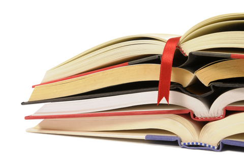 Small pile of open books with red bookmark ribbon isolated on white background