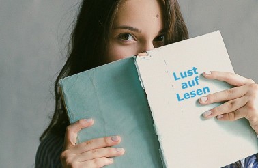 woman-in-blue-striped-flannel-shirt-holding-a-book-indoors-698928